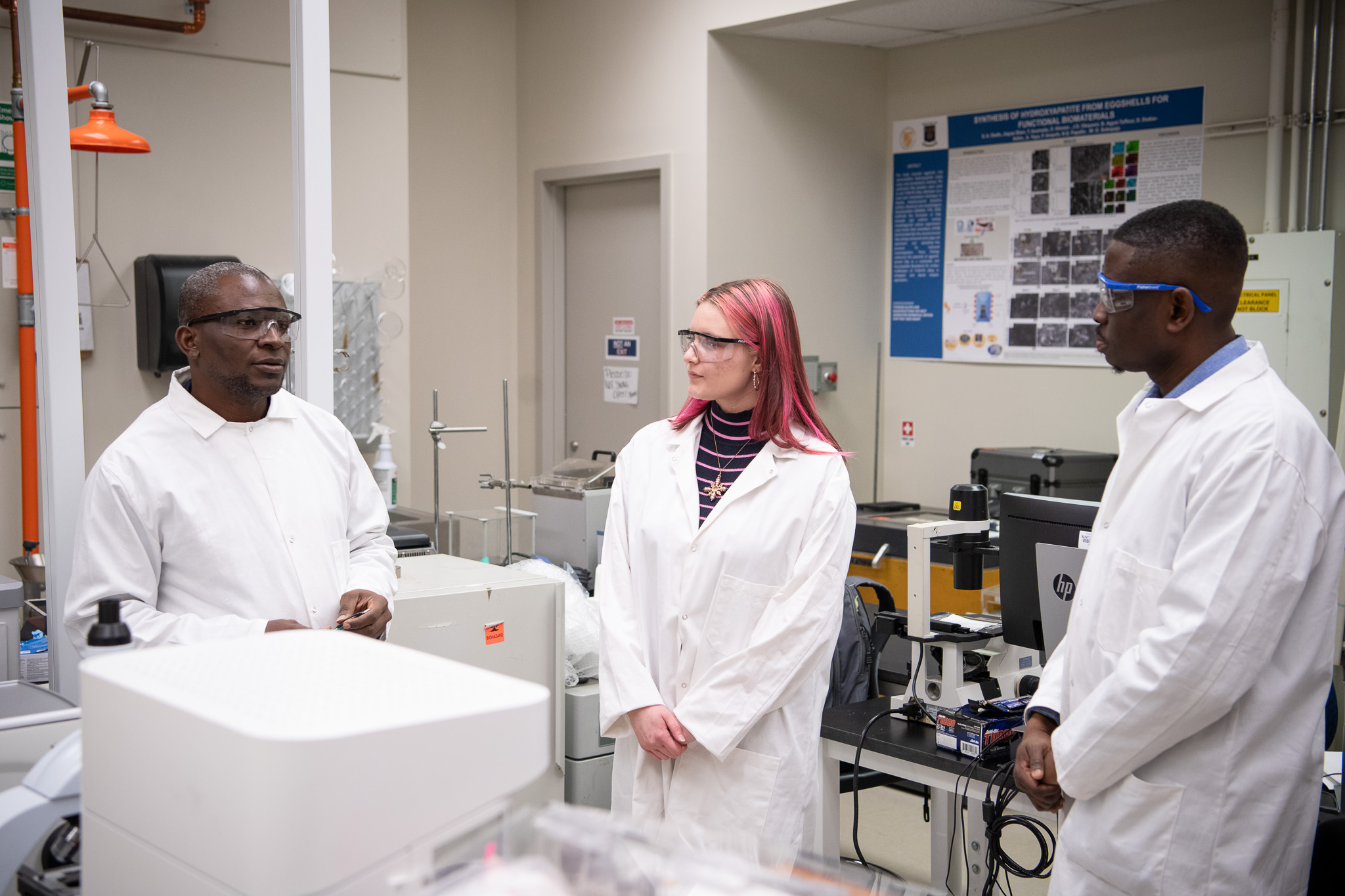 A SUNY Poly student researcher in a laboratory with two faculty researchers.